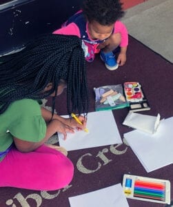 Two girls using supplies from grab and go art kits