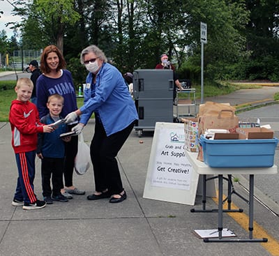 Edmonds Arts Festival Foundation Board member Diane Cutts distributes art supplies to students as part of the Foundation's Grab-and-Go Art Supply program